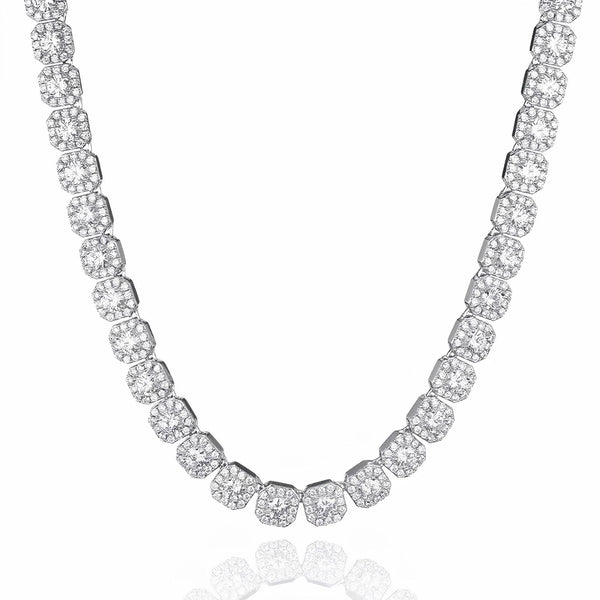 A silver-toned tennis necklace paved with round and cushion-cut clear stones, displayed on a clean white background with a subtle reflection below.