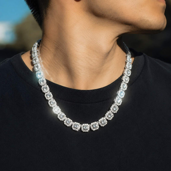 A close-up lifestyle shot of a man wearing a silver-toned cubic zirocnia tennis chain necklace over a black t-shirt.