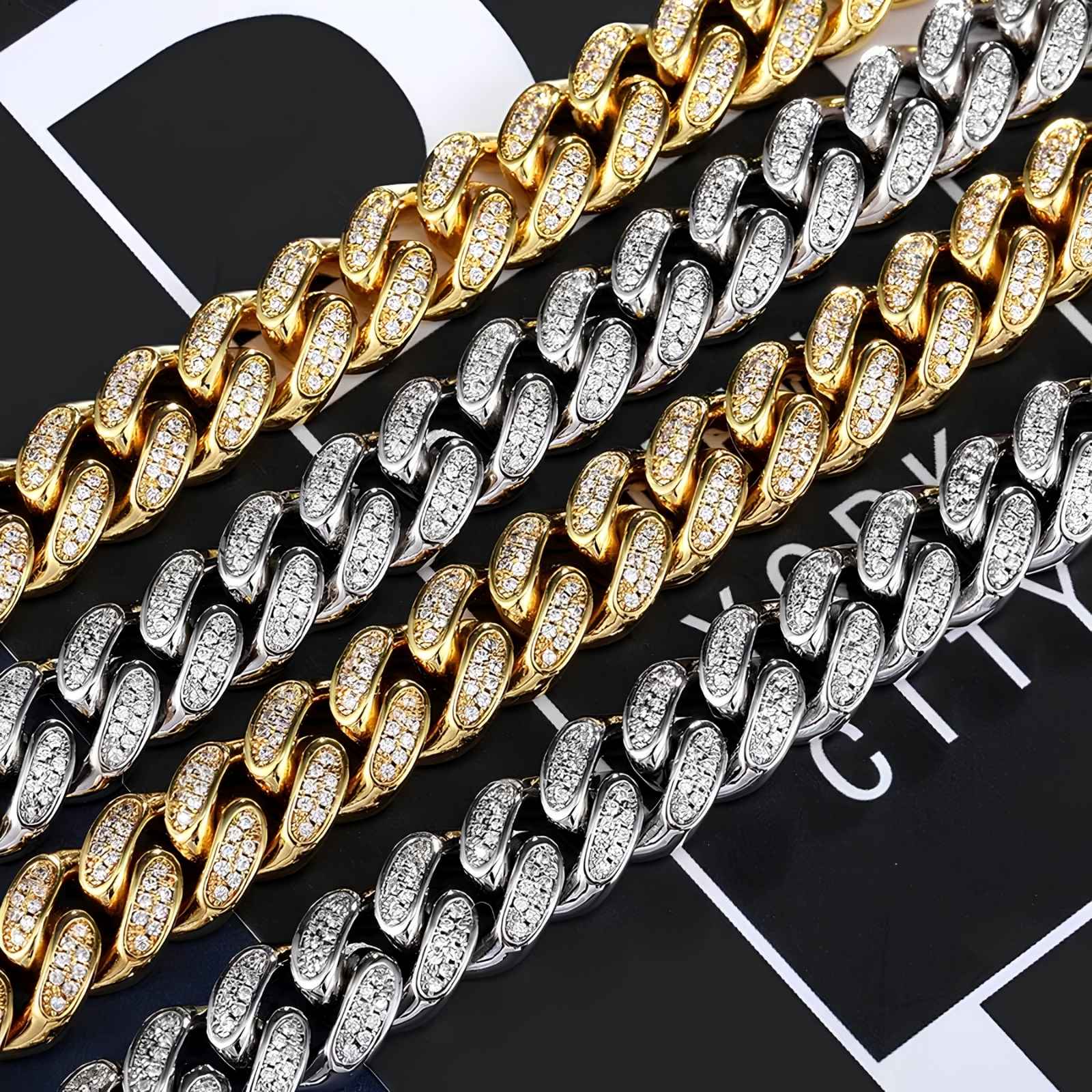 Four Cuban links in gold, silver, and two-tone finishes, each paved with small clear stones, arranged diagonally on a black and white graphic background.