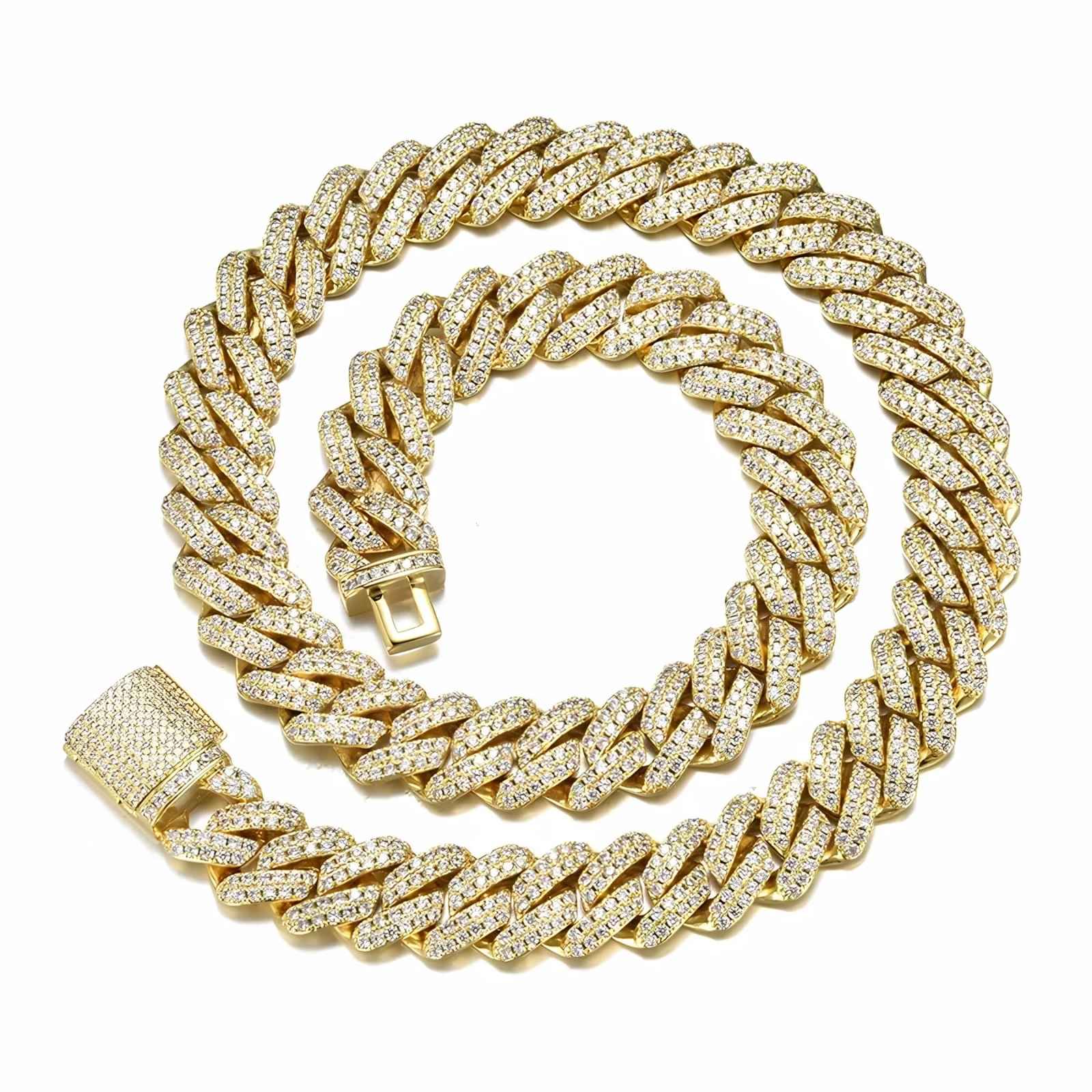 A thick gold Cuban link chain necklace, heavily embellished with small clear stones, coiled on a plain white background.
