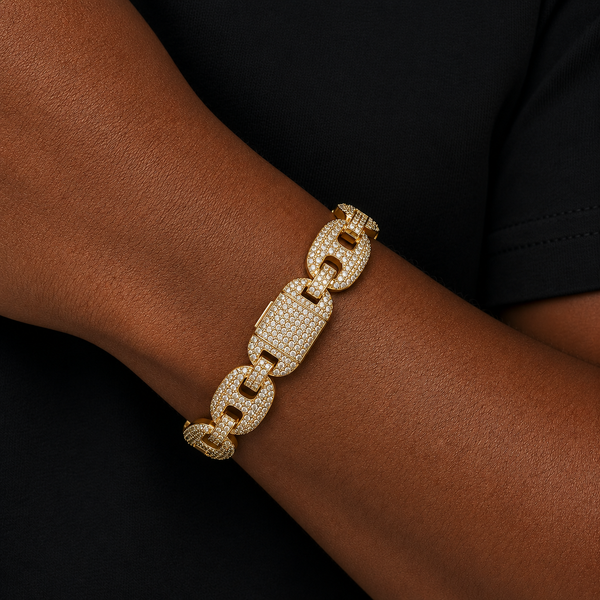 Male model wearing a 12mm iced puff Cuban bracelet in gold with pavé cubic zirconia stones on wrist