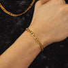 Gold chain and bracelet on a model against a dark background
