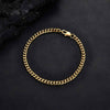A gold-toned curb chain bracelet with a lobster clasp, displayed on a textured black background.