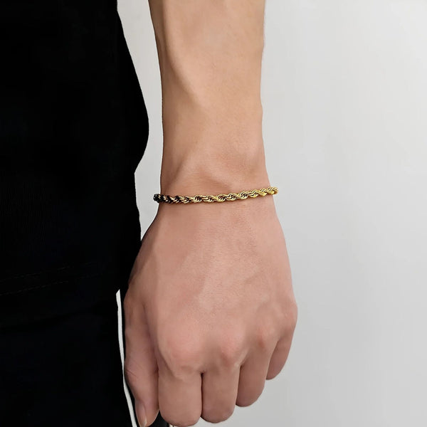 Gold bracelet on a wrist against a neutral background