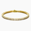 A gold tennis bracelet featuring a row of clear round-cut cubic zirconia, displayed on a clean white background.