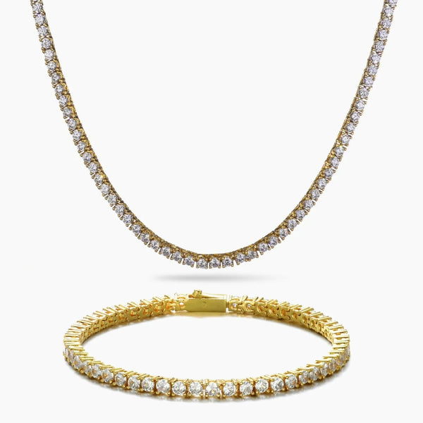 A gold tennis necklace and matching gold tennis bracelet, both adorned with clear cubic zirconia stones, displayed on a clean white background.