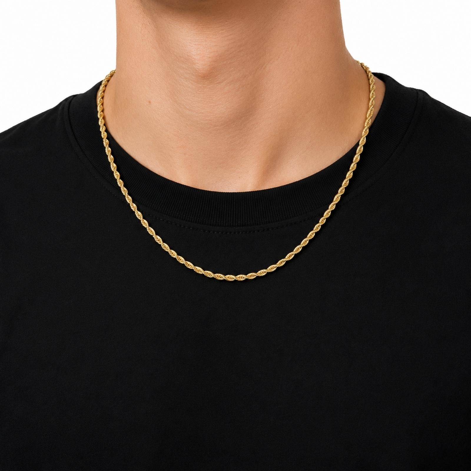 A close-up of a person's neck and upper chest wearing a gold rope chain necklace over a black crewneck t-shirt, against a plain white background.