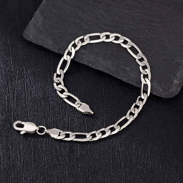 Silver figaro chain bracelet on a dark stone surface