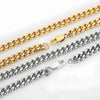 Two metal chain necklaces laid diagonally on a white background, one in polished gold and one in polished silver, both showing a curb-style link design and lobster clasp.