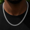 A close-up of a man's neck and chest wearing a thick, polished silver Cuban link chain necklace over a black t-shirt.