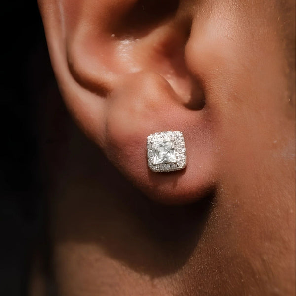 Close-up of an ear wearing a cubic zirconia earring with a dark background