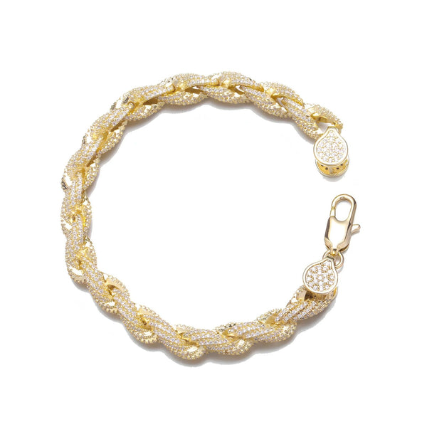 A gold-toned braided chain bracelet paved with small clear stones, shown on a plain white background. The bracelet has a lobster clasp closure and a small round charm.