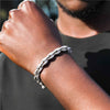 Close-up of a wrist wearing a textured bracelet with a blurred background