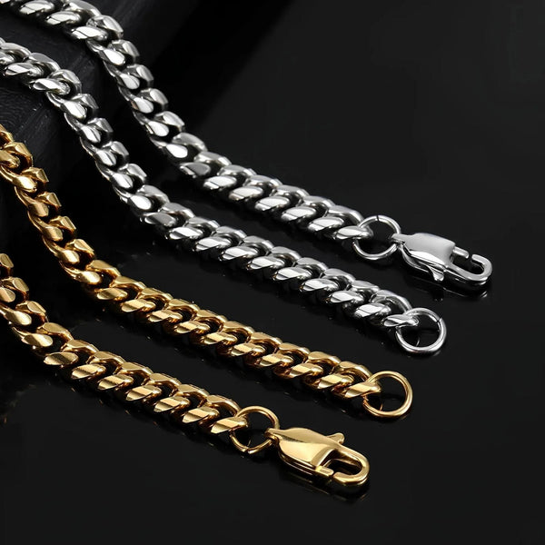 Two chain necklaces, one gold and one silver, on a black background.