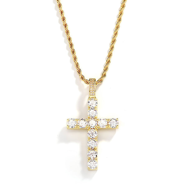 A gold cross pendant necklace adorned with clear cubic zirconia stones, suspended from a gold rope chain against a white background.