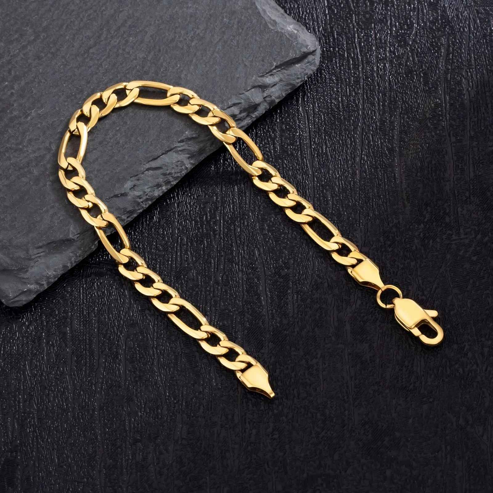 Gold chain bracelet on a black surface