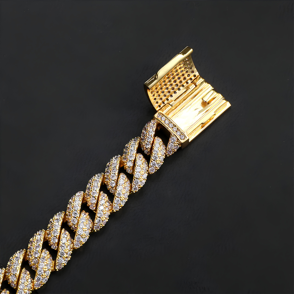 Close-up of the clasp and links on a gold iced Cuban bracelet with cubic zirconia stones against a black background.