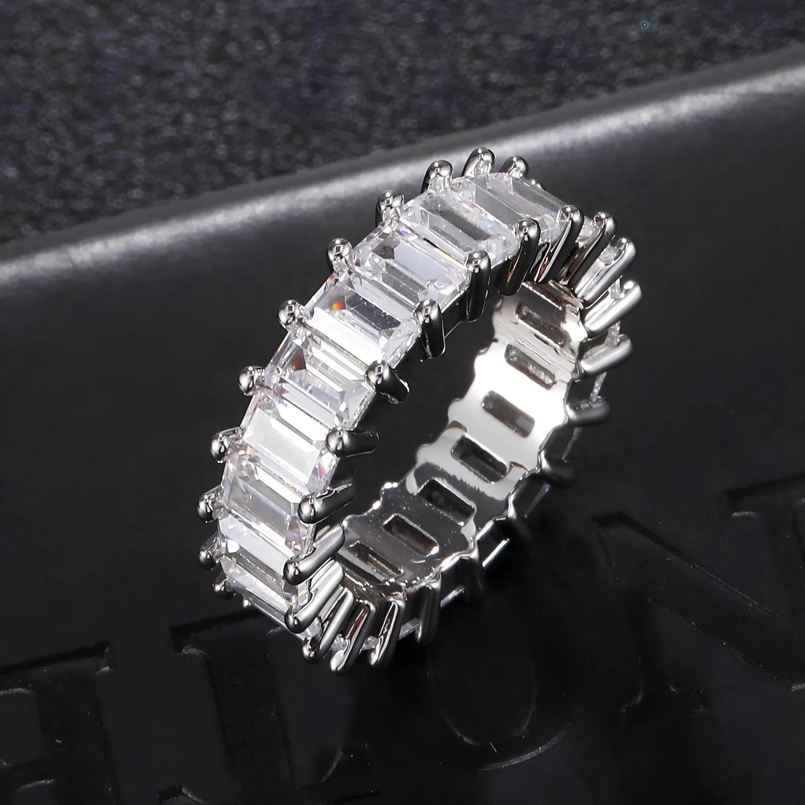 Silver ring with emerald-cut cubic zirconia on a dark textured background