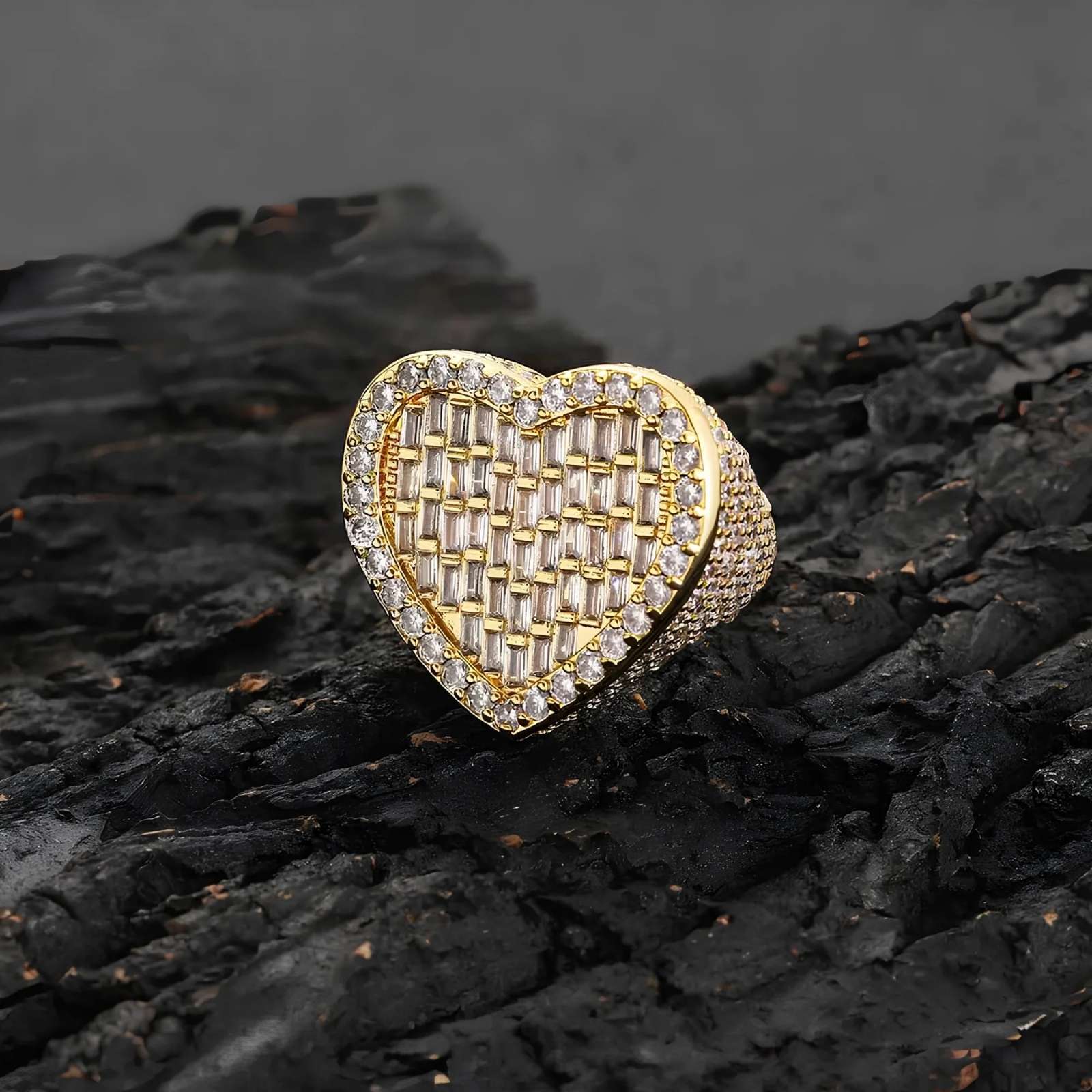Gold heart-shaped ring with cubic zirconia stones on a dark textured surface