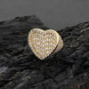 Gold heart-shaped ring with cubic zirconia stones on a dark textured surface