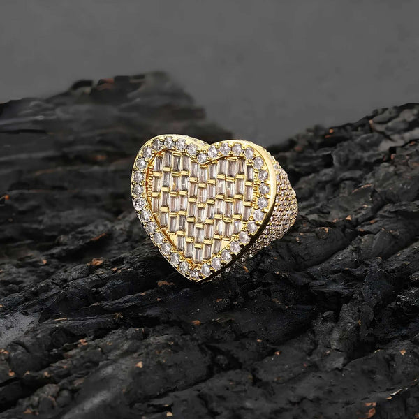 Gold heart-shaped ring with cubic zirconia stones on a dark textured surface