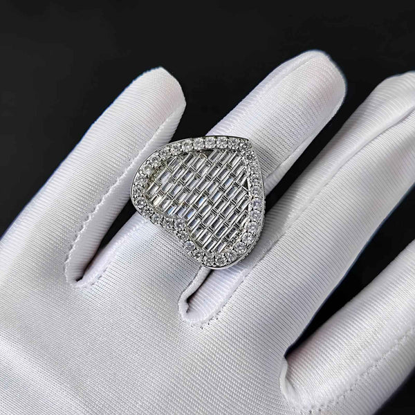 Silver ring with cubic zirconia on a white gloved hand against a black background