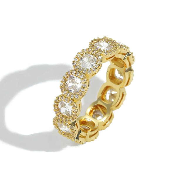 A gold eternity-style band ring featuring a row of clear oval-cut cubic zirconia in halo settings, photographed on a white background with a soft shadow.