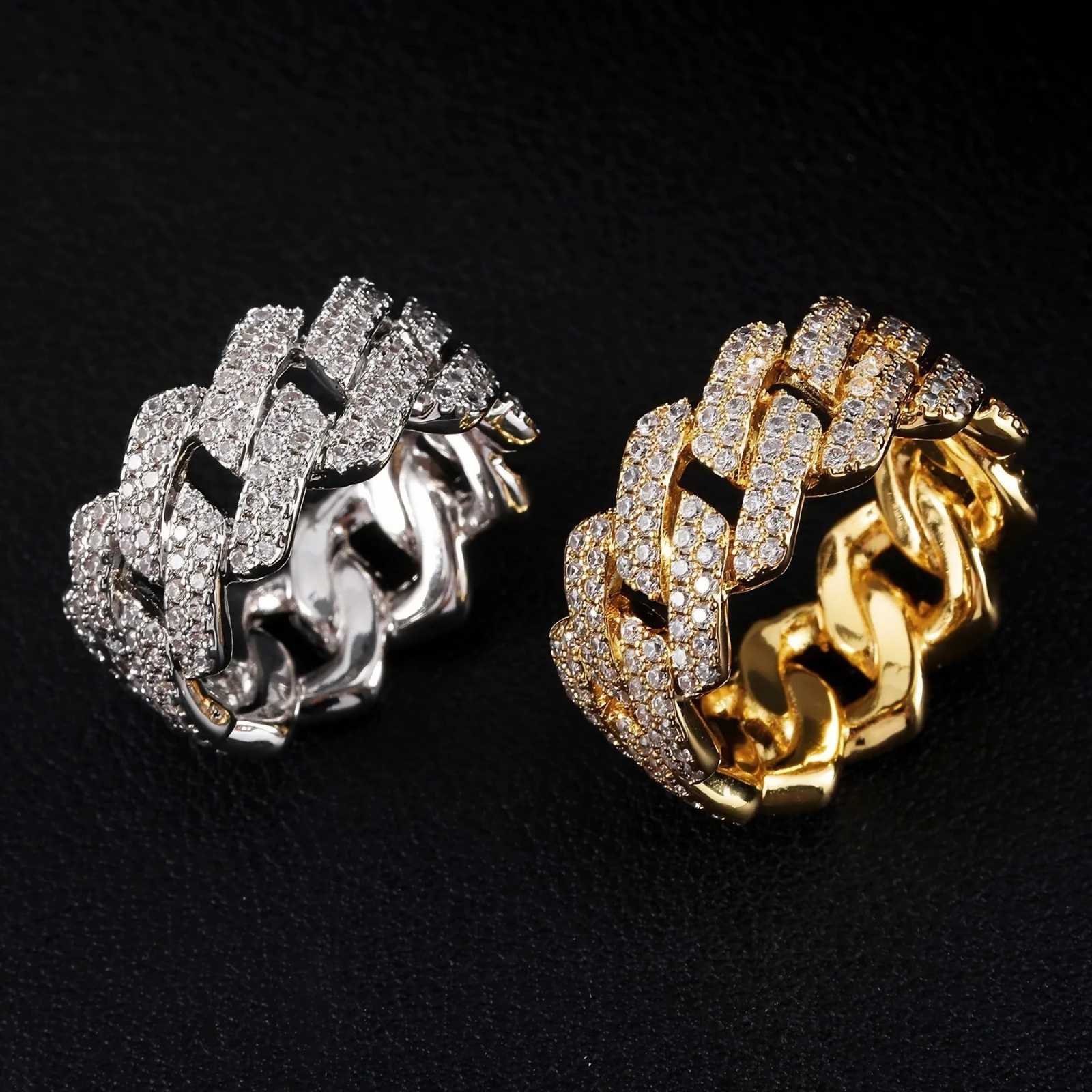 Two Cuban link rings with pavé-set clear stones, shown side by side on a black textured background. One ring is silver-toned and the other is gold-toned.