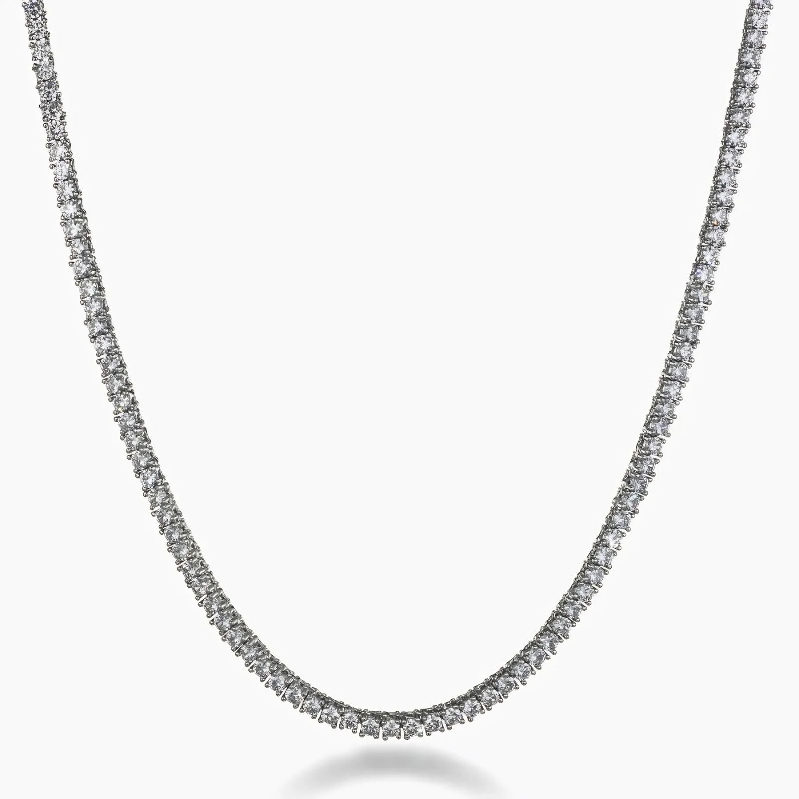 A silver-toned tennis chain necklace paved with small clear stones, shown against a plain white background.