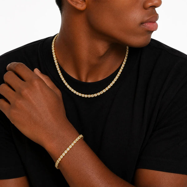Person wearing a gold tennis necklace and bracelet on a plain background