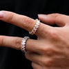 Close-up of hands wearing cubic zirconia gold and silver rings on a black background