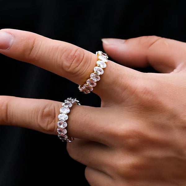 Close-up of hands wearing cubic zirconia gold and silver rings on a black background