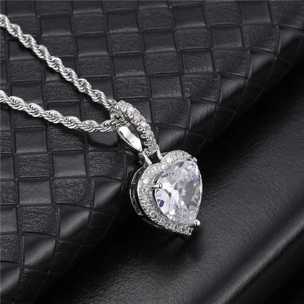 Angled view of silver iced heart halo pendant necklace on black display surface