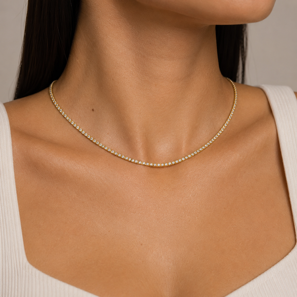 Woman wearing a 3mm gold tennis chain necklace with cubic zirconia stones.