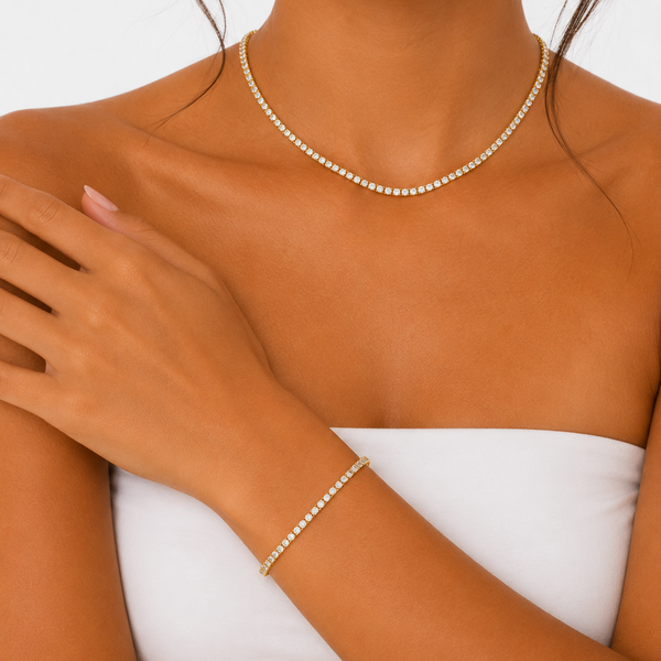 Woman wearing a matching 3mm gold tennis chain and bracelet set.